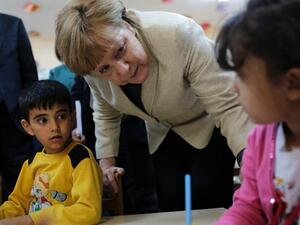 German Chancellor Angela Merkel talks with refugee children at a preschool, during a visit to a refugee camp in Turkey. [AFP]
