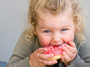 صورة تعبيرية لطفلة تتناول الحلويات 