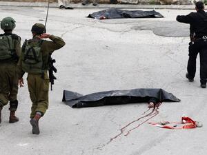 IDF soldiers surround the body of al-Sharif after he was shot and killed. (AFP/Hazem Bader)