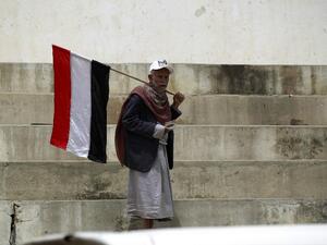 A Houthi man carries a Yemeni flag in the capital city, Sanaa. (AFP/Mohammed Huwais) A Houthi man carries a Yemeni flag in the capital city, Sanaa. (AFP/Mohammed Huwais)