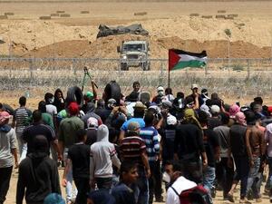 Palestinian demonstrators gesture towards Israeli forces during clashes along the Gaza border (AFP photo)