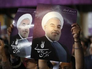 Supporters of Iranian presidential candidate Hassan Rouhani hold his portrait during a campaign rally in the capital Tehran on May 4, 2017. (AFP/Atta Kenare)
