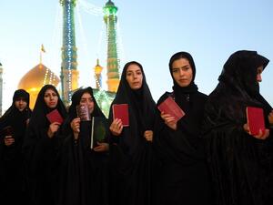 Iranian women hold their ID as they wait in line to cast their votes for municipal and presidential elections at a polling station at the Massoumeh shrine in the holy city of Qom, 130 kms south of Tehran, on May 19, 2017. (AFP/Ali Shaigan)