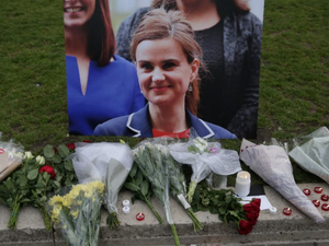 Flowers and candles are placed next to a picture of murdered Labour MP Jo Cox at a vigil in Parliament Square in London on June 16, 2016 (AFP Photo/Daniel Leal-Olivas)