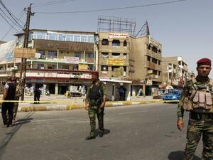 Iraqi security forces stand guard at the site of a suicide bomb attack at a market in the Baghdad Jadida neighborhood in the east of the capital on September 27, 2016. (AFP/Sabah Arar)