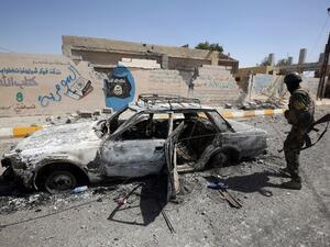 A member of the Iraqi government forces looks at a burnt-out vehicle as they secure the town of Sharqat, around 50 miles south of Mosul, on September 23, 2016, the day after recapturing city from Daesh. (AFP/Ahmad al-Rubaye)