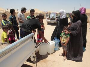 Iraqis who fled fighting between government forces and Daesh in Fallujah fill jerrycans with water at a camp for displaced people in Amriyat al-Fallujah on June 14, 2016. (AFP/Sabah Arar)