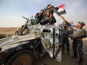 Iraqi forces receive fruits on a road near in the village of Arbid on the southern outskirts of Mosul on November 9, 2016, during the ongoing military operation to retake Mosul from Daesh. (AFP/Ahmad al-Rubaye)