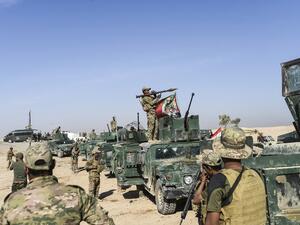 Members of Iraqi pro-government forces drive towards the frontline on October 21, 2016 near the village of Tall al-Tibah, some 30 kilometers south of Mosul. (AFP/Bulent Kilic)