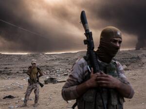 Iraqi soldiers look on as smoke rises from the Qayyarah area, some 35 miles south of Mosul, on October 19, 2016, as Iraqi forces take part in an operation against Daesh to retake the main city. (AFP/Yasin Akgul)