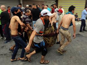 Iraqis evacuate a body from the site of a suicide car bombing claimed by the Islamic State group on July 3, 2016 in Baghdad's central Karrada district. (AFP/Sabah Arar)