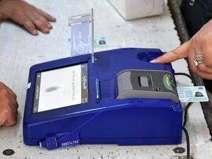An Iraqi voter has her biometric voting card checked with her fingerprint upon arriving at a poll station for the parliamentary elections in the northern multi-ethnic city of Kirkuk on May 12, 2018. (Marwan Ibrahim/ AFP)