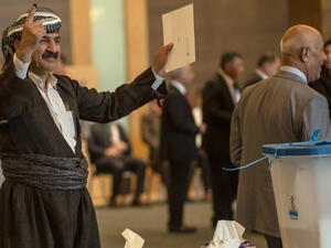 An officials of Kurdistan Regional Government shows his ink-stained finger after casting his vote. (Ahmed Deeb / AFP)