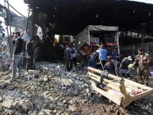 Iraqis salvage vegetables from the site of an attack at Baghdad's main vegetable market on January 8, 2017. (AFP/Sabah Arar)