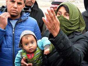 Displaced Iraqis, who fled the violence around the northern Iraqi city of Mosul, wait to receive food aid at the al-Khazer refugee camp east of Erbil, on January 31, 2017. (AFP/Mahmud Saleh)