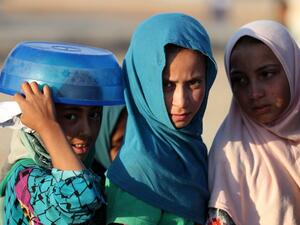 Displaced Iraqis receive aid food during the Muslim holy month of Ramadan at al-Khazir camp for the internally displaced, located between Arbil and Mosul, on June 5, 2017. (AFP/Karim Sahib)