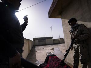 Two Iraqi army soldiers take position on the rooftop of a house during a battle against the Islamic State (IS) group near the Fourth Bridge over the Tigris River connecting eastern and western Mosul on January 10, 2017. (AFP/Dimitar Dilkoff)