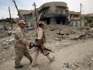 Members of the Iraqi forces patrol streets in the western neighborhood of Tamuz in Mosul on May 23, 2017, after the area was retaken during the ongoing offensive against Islamic State (IS) group fighters. (AFP/Ahmad al-Rubaye)
