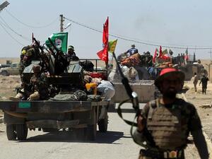 Members of the Iraqi pro-government Hashed al-Shaabi (Popular Mobilisation) paramilitary forces gather in a street in the modern town of Hatra, near the eponymous UNESCO-listed ancient city, southwest of the northern city of Mosul, on April 28, 2017. (AFP/Ahmad al-Rubaye)