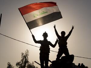 Iraq's federal police members wave Iraq's national flag as they celebrate in the Old City of Mosul on July 9, 2017 after the government's announcement of the "liberation" of the embattled city. (Fadel Senna/AFP)
