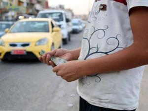 Vicious cycle. An Iraqi child holds banknotes in the northern Iraqi city of Mosul, last July. (AFP)