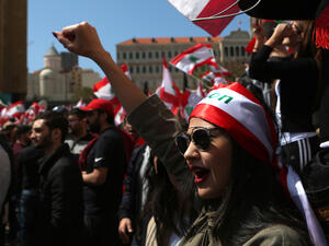 A Lebanese woman raises her fist as she shouts slogans during a protest in downtown Beirut on March 19, 2017, against the Lebanese Parliament's newly approved taxes. (AFP/Patrick Baz)