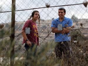 Two Israeli settlers watch Palestinian villagers following a price-tag attack in the West Bank. (AFP/File)