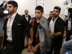 Ahmed Manasra (C), a 14-year old Palestinian boy, convicted of the attempted murder of two Israelis in a stabbing in October 2015, leaves the District Court in Jerusalem after his sentencing hearing on November 7, 2016. (AFP/Ahmad Gharabli)
