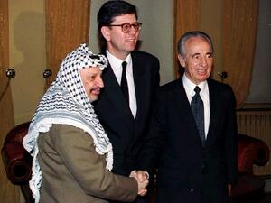 This file photo taken on January 22, 1994 shows Israeli Foreign Minister Shimon Peres (R) and PLO Chairman Yasser Arafat (L) shaking hands as they pose with the new Norwegian Foreign Minister Bjoern Tore Godal in Oslo. (AFP/Stringer)