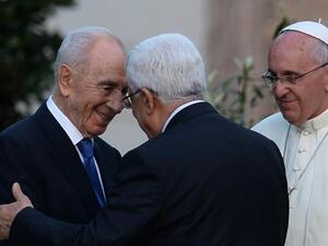 Israeli President Shimon Peres (left) shakes hands with Palestinian leader Mahmud Abbas as Pope Francis looks on following a peace summit at the Vatican, on June 8, 2014 (AFP/Filippo Monteforte)