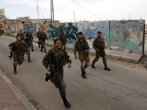 Israeli soldiers run down a road in Hebron, in the occupied West Bank, April 12 2017. (AFP/Hazem Bader)