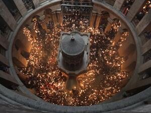 Christian Orthodox worshippers hold up candles during the ceremony of the "Holy Fire" as thousands gather in the Church of the Holy Sepulchre in Jerusalem's Old City, on April 15, 2017, during Orthodox Easter ceremonies. (AFP/Menahem Kahana)