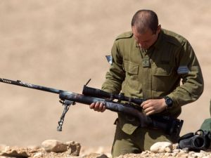Israeli soldiers cheer as sniper shoots unarmed Palestinian near the border fence in the besieged Gaza Strip (AFP/ File Photo)