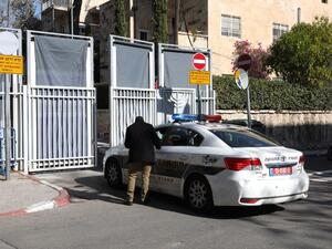 An Israeli police car is seen at the entrance to the residence of Israeli Prime Minister Benjamin Netanyahu as members of the media wait for the arrival of police investigators on January 2, 2017. (AFP/Gali Tibbon)