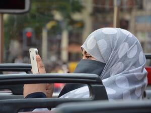 Woman in niqab snaps a photo with her phone