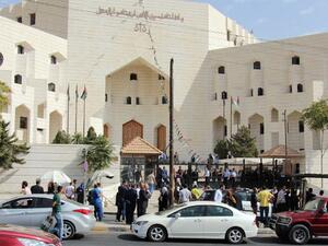 Police and civilians gather outside the court in Amman's Abdali neighborhood, where cartoonist Nahed Hattar was shot and killed. (AFP/Ahmad Alameen)