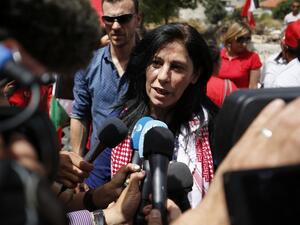 Prominent Palestinian lawmaker Khalida Jarrar greets speaks to reporters in her hometown, the West Bank city of Ramallah, following her release from an Israeli jail on June 3, 2016. (AFP/Abbas Momani)