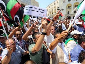 Protesters shout slogans waving national flags during a demonstration on Algeria Square to demand the removal of arms and the evacuation of unofficial armed groups on July 7, 2013 in the Libyan capital Tripoli.(MAHMUD TURKIA /AFP)