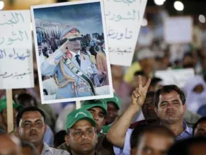 القذافي يوزع السلاح على الليبيين