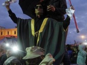 شاب يتشبه بالقذافي مستهزءا به خلال احتجاج في بنغازي
