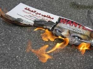 ملصق يحمل صورة القذافي وقد اشتعلت فيه النار