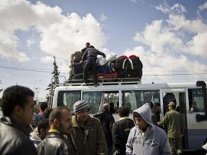 مجموعة من الرجال الذين غادروا ليبيا ينتظرون عند معبر راس جدير الحدودي قرب مدينة بن قردان التونسية
