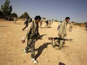 ثوار يتخذون مواقعهم بالقرب من طريق رئيسي مؤدي الى قرية القواليش 