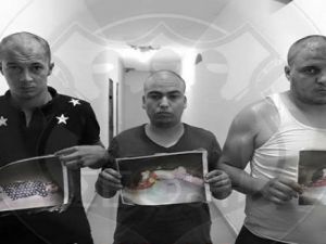  تصوير الثلاثة وهم يحملون صورا لأطفال موتى تم انتشال جثثهم من الساحل