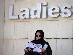 A female candidate stands underneath the "Ladies" voting area sign after casting her ballot. (AFP/Fayez Nureldine)