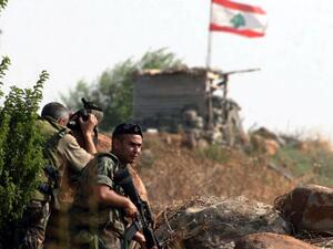 Lebanese army soldiers on patrol, as their country's flag waves in the background. (AFP/File)