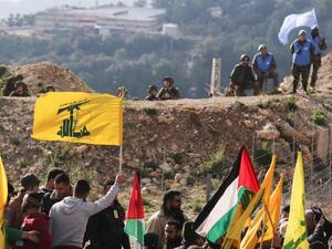 Hizbollah supporters hoist their flags as part of the elections campaign Lebanon is going through (AFP/File Photo)	