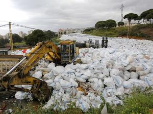 Workers use a front-loader to move piles of garbage from Jdeideh, a Beirut suburb, to the country's largest landfill of Naameh, just south of the Lebanese capital, on March 20, 2016.  (AFP/Anwar Amro)