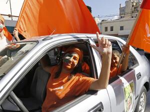 Supporters of Lebanese presidential candidate Michel Aoun drive waving political flags ahead of a parliament session expected to elect the ex-general as president and end a political stalemate of more than two years, on October 31, 2016. (AFP/Anwar Amro)
