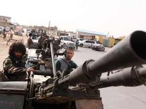 Members of Libya Dawn drive pickup trucks outfitted with machine guns after clashes with Daesh in Sabratha, Libya. (AFP/Mahmud Turkia)